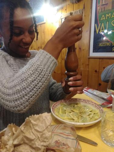 a woman holding a wooden spoon over a plate of food at B&B Ma Maison in Govone