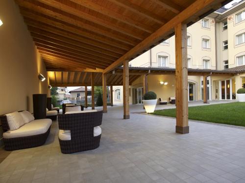an outdoor patio with a wooden pergola at Virginia Palace Hotel in Garbagnate Milanese