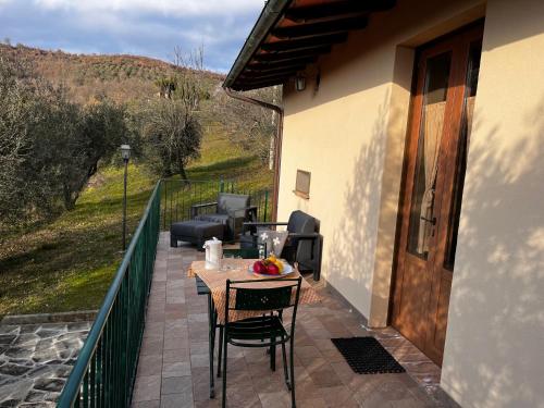 eine Terrasse mit einem Tisch und Stühlen auf dem Balkon in der Unterkunft Agriturismo Il Mulino delle canutole in Magione