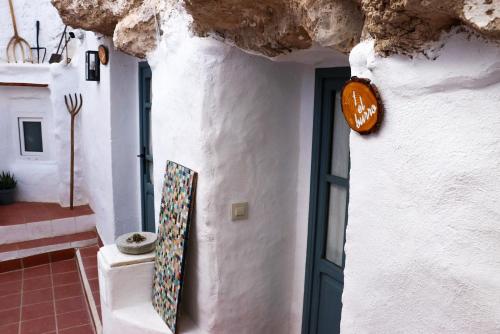 een deur naar een wit gebouw met een groene deur bij La Cueva Blanca in Alcalá del Júcar