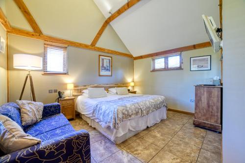 a bedroom with a bed and a couch at The Grove Cromer in Cromer