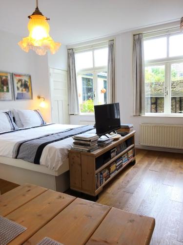 a bedroom with a bed and a television on a table at B&B Vierwinden in Vlissingen