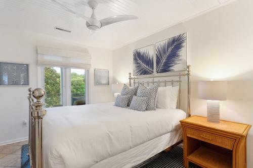 a white bedroom with a bed and a table at 1001 E Arctic Out of the Blue Stunning Oceanfront Home in Folly Beach