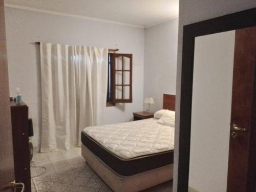 1 dormitorio con cama y ventana en Casa en ostende pinamar en Ostende