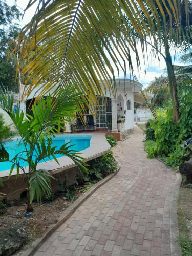 een huis met een zwembad en een palmboom bij Villa Igor in Cancun