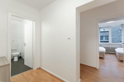 een lege witte kamer met een toilet en een raam bij T&K Apartments - 3 Room Apartment in Mülheim an der Ruhr