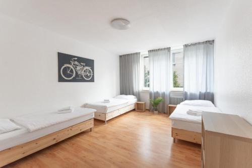 een kamer met drie bedden en een fietsfoto aan de muur bij T&K Apartments - 3 Room Apartment in Mülheim an der Ruhr