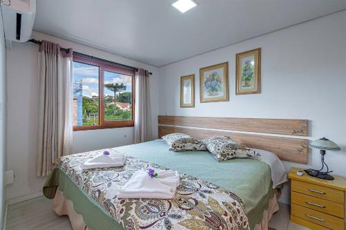 1 dormitorio con 1 cama con toallas en Solar da Encosta - Stay House Temporada, en Gramado