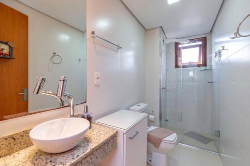 y baño con lavabo, aseo y ducha. en Solar da Encosta - Stay House Temporada, en Gramado
