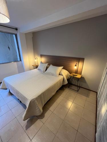1 dormitorio con cama grande y ventana grande en Departamentos del Sol para 4 personas Reciclado a Nuevo en Mendoza
