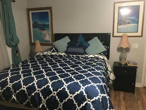 1 dormitorio con 1 cama azul y blanca y 2 lámparas en Romantic Coastal Private Room, en Oxnard