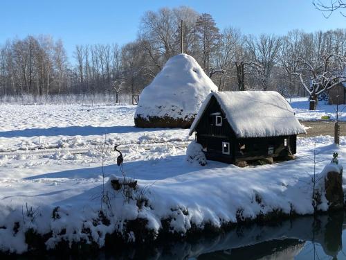 a snow covered cabin in a field with a snow mound at Kauperhof in Burg