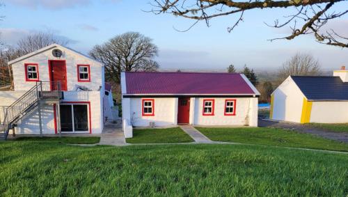 a house with a red door and a white house at Tiernan's Luxury Accommodation in Newtown-Dillon