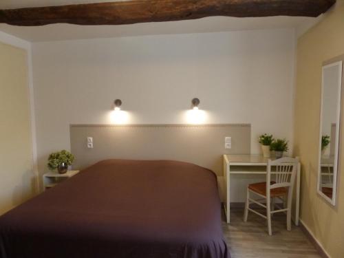 a bedroom with a large bed and a desk at Auberge de Trente Pas in Saint-Ferréol-Trente-Pas