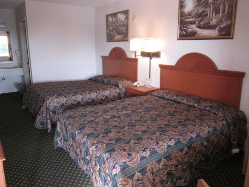 um quarto de hotel com duas camas e duas lâmpadas em Westmont Inn - Lakeland em Lakeland