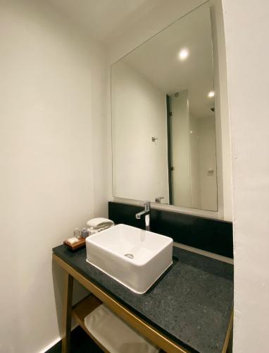 a bathroom with a white sink and a mirror at B's Suites Mérida in Mérida