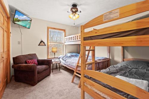 a bedroom with two bunk beds and a chair at THE ONE Chalet in Albrightsville