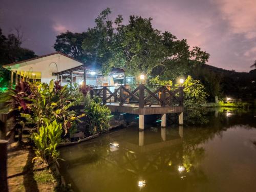 a bridge over a body of water at night at Seu Refúgio Rural Piscina Privativa e Natureza in Tubarão