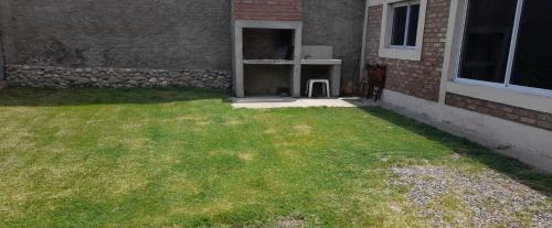 un patio trasero con césped al lado de un edificio en Complejo Martinez II Tupungato en Tupungato