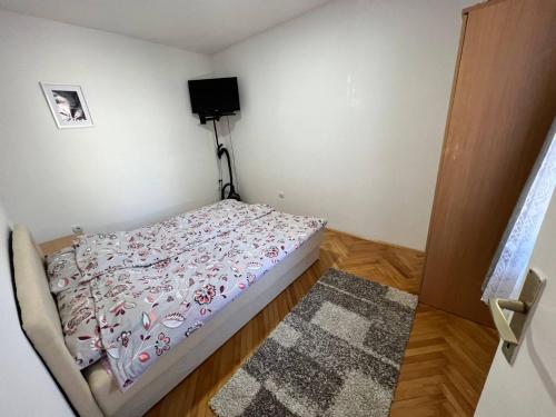 a small bedroom with a bed and a television at Vuk in Zlatibor