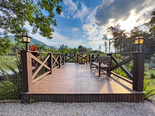a wooden boardwalk with a bench on it at Seu Refúgio Rural Piscina Privativa e Natureza in Tubarão