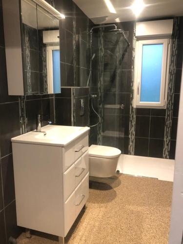a bathroom with a sink and a toilet and a shower at La Perle Rare - spa in La Selle-en-Coglès