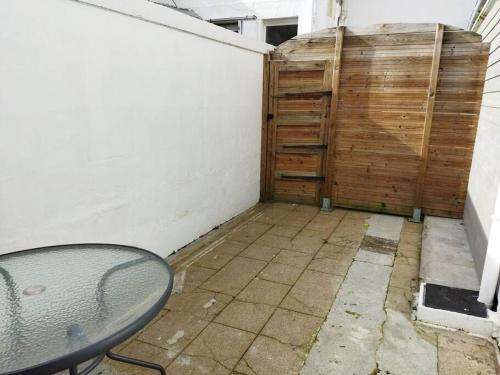 a patio with a table and a wooden fence at Logement idéal curistes in Rochefort