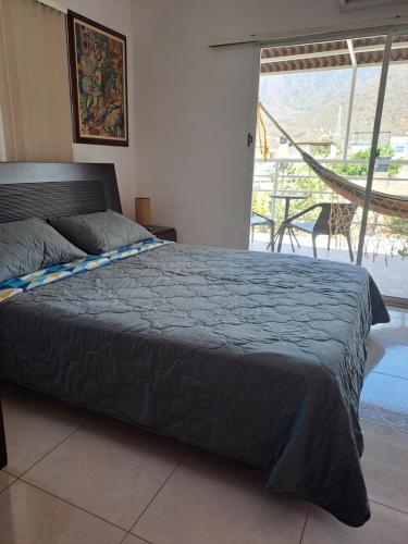 1 dormitorio con cama y vistas a un balcón en Villa Layla Santa Marta, en Santa Marta