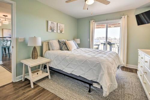 a bedroom with a bed and a window with a view at Oak Island Condo - Walk to the Beach! in Oak Island