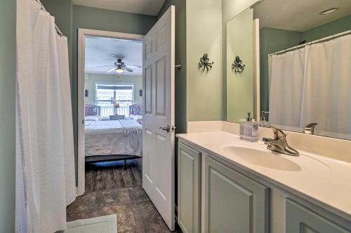 a bathroom with a sink and a mirror and a bedroom at Oak Island Condo - Walk to the Beach! in Oak Island