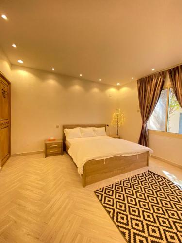 a bedroom with a large bed and a window at فيلا آفيري Aviary villa in AlUla