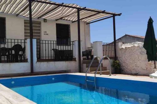 una piscina en una villa con una casa en CASA RURAL LOS ALTOS, en Ojuelos Altos