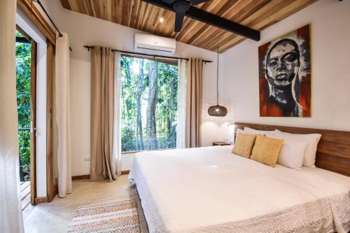 a bedroom with a large bed and a large window at Satta Lodge in Puerto Viejo