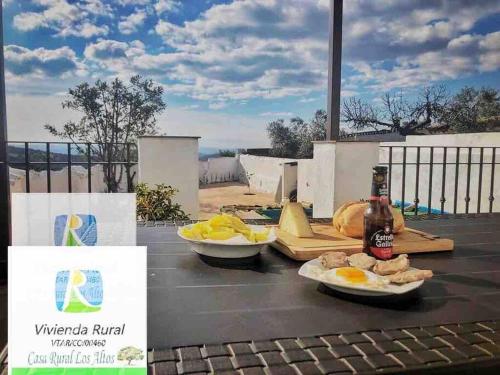 una mesa con platos de comida y una botella de cerveza en CASA RURAL LOS ALTOS, en Ojuelos Altos