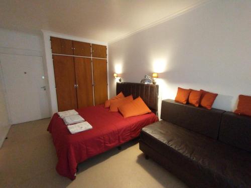 a bedroom with a bed and a couch at Hermoso Apartamento en el centro de Buenos Aires. in Buenos Aires