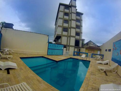 a large swimming pool in front of a building at Hotel Sirena in Praia Grande