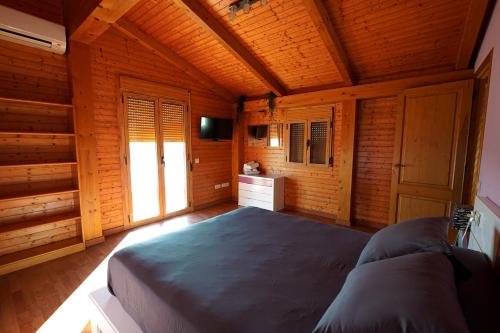 una camera da letto con un grande letto in una camera in legno di Casa la Pau a Deltebre