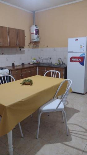 a kitchen with a table with a yellow table cloth on it at HERMOSA CASONA ANTIGUA Y LUMINOSA in Villa María