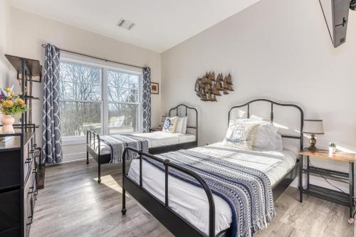 a bedroom with two beds and a window at Beachside Waterview 2Br Condo w/ Pool in Greenport in Greenport