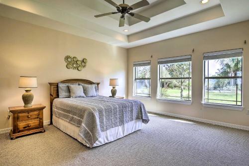 a bedroom with a bed with a ceiling fan and windows at Bright Laguna Vista Home with Community Pool! in Laguna Vista