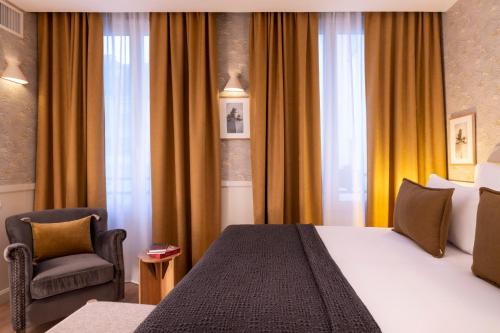 a hotel room with a bed and a chair at Le Petit Oberkampf Hotel & Spa in Paris