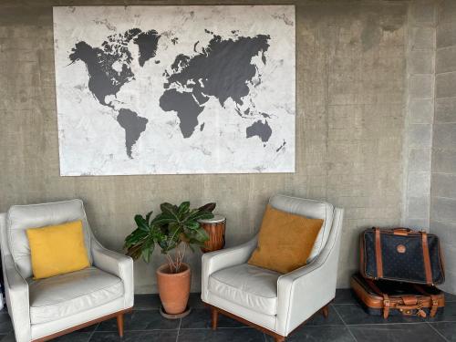 dos sillas y un mapa del mundo en la pared en Loft industrial vista a los volcanes en Cholula
