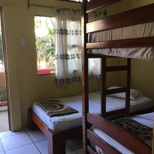 two bunk beds in a room with a window at Hostal Machalilla in Puerto López