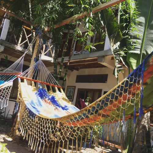 a hammock is hanging in front of a house at Hostal Machalilla in Puerto López