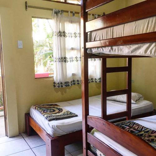 2 Etagenbetten in einem Zimmer mit Fenster in der Unterkunft Hostal Machalilla in Puerto López