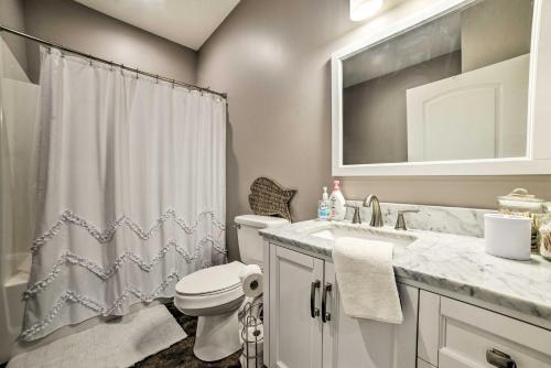 een badkamer met een toilet, een wastafel en een spiegel bij Pet-Friendly Murray Vacation Rental with Grill! in Murray