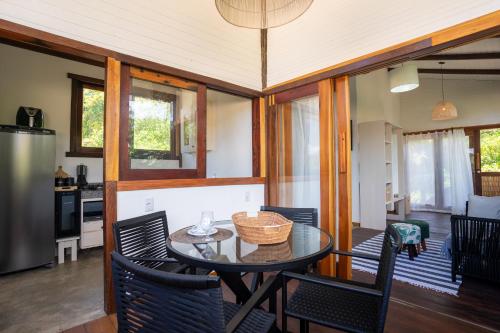 cocina y comedor con mesa y sillas en Akua Bungalows, en Maraú