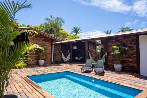 un patio trasero con piscina y una casa en Akua Bungalows, en Maraú