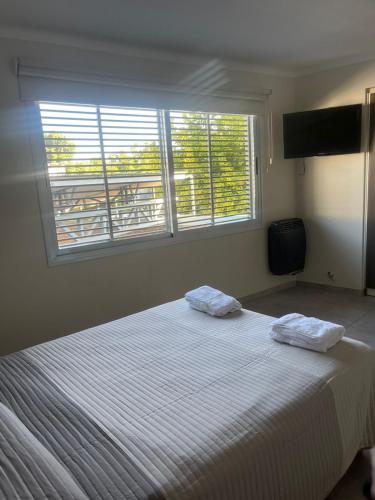 1 dormitorio con 1 cama grande y 2 toallas. en Departamento Ciudad de Tupungato en Tupungato