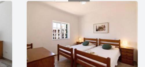 1 dormitorio con 2 camas, escritorio y ventana en Apartment Moni Cabanas de Tavira Algarve, en Cabanas de Tavira